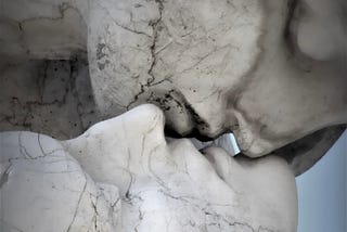 kiss among marble statuette heads