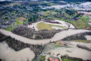 Photo of the area for the Fall City Floodplain Restoration Project, showing river water, farmland, and housing.