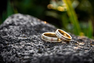 Two wedding rings on a rock