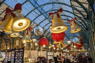 Gold bells, red baubles, silver glitter balls and curved roof of market.