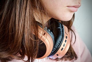 over-ear headphones around the neck of a young woman