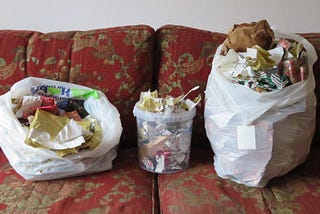 Two sacks of Christmas wrap for recycling with a tub of bits in the centre.
