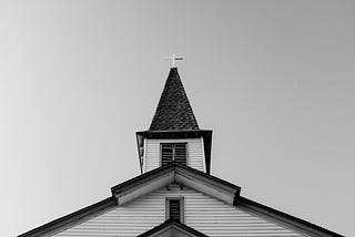 black and white image of top of Christian church