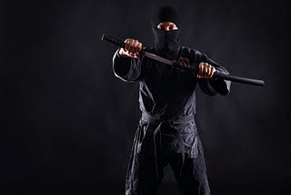 A ninja with a half-sheathed katana.