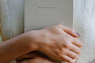 the women holds spiritual journal in her hands