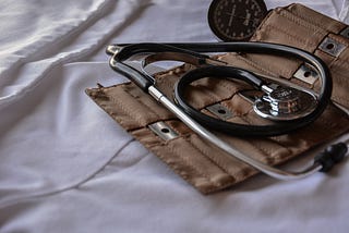 Medical tools displayed on a bed with white sheets.