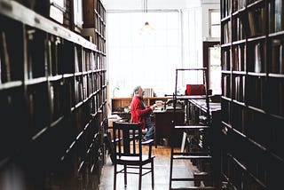 A man sits at a desk in a book shop