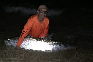 Fisherman Fights Fish Into The Night From The Beach