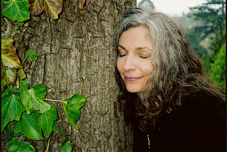 Author resting cheek against big old tree