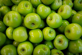 A lot of shiny green apples.