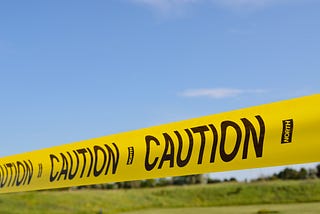 Caution tape against a bright blue sky