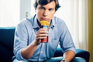 AI generated image of Tucker Carlson in a button up shirt eating what looks like gross fries in a soda can or something.