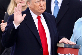 An image of President Donald Trump being sworn into office with his hand on two bibles.