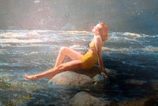 1940s hand-tinted photograph of woman on a rock in river