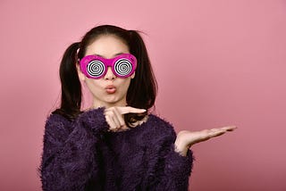 A woman with googly eyes pointing to the left. Marriage, womne, humor