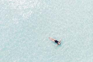 A woman floating alone peacefully in the ocean