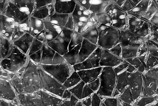 Black and white close-up image of shattered glass