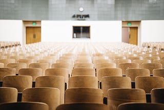 A lecture hall filled with empty chairs.