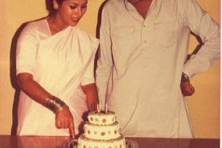 Shumi standing with a 3-tier cake in a retro picture from the 90's