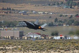 A fighter jet flying low to the ground.