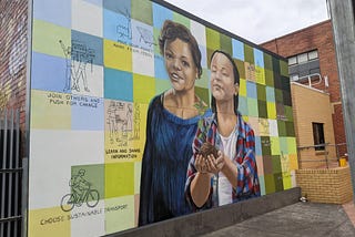 the mural reads “move your money away from fossil fuels”, “join others and push for change”, “learn and share information”, “choose sustainable transport”, “support locally grown produce”, “look out for each other”, “eat plant-based foods” and “protect nature in urban environments”