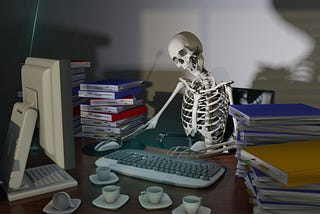 Photo of a distracted skeleton at computer surrounded by coffee and books