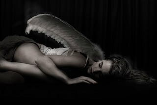 woman with angel wing lying on floor