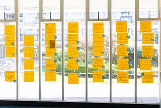 Unconference board with participant-suggested sessions on yellow sticky notes.