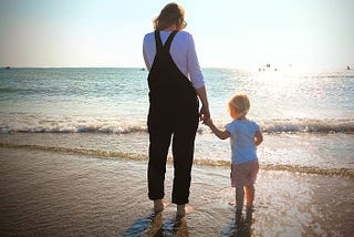 Wife and daughter at the beach looking out to sea