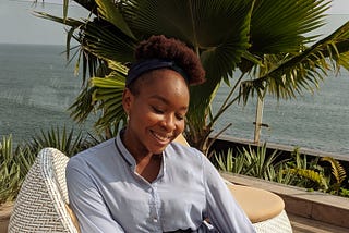 A beautiful lady sitting on a balcony overlooking the ocean