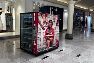 photo of a soda machine with poster on side
