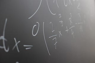 A close up of a mathematical equation on a blackboard.