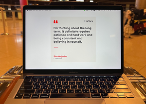 an laptop on a briefcase at an airport used for writing a startup journey