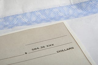 A payroll check on top of an envelope.