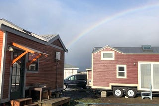 two tiny houses under a rainbow
