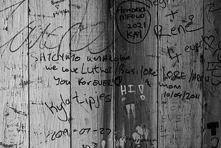 Names graffitied on a wooden wall