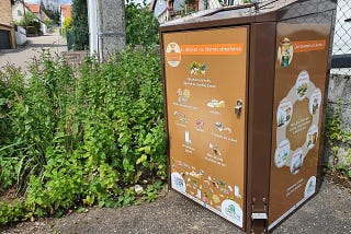 A brown food waste garbage can in a village.