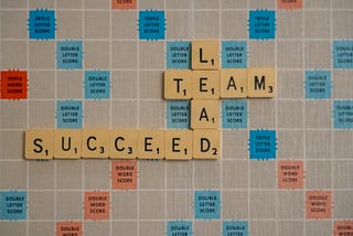 Quadro de letras formando em inglês as palavras "Lead team succeed"