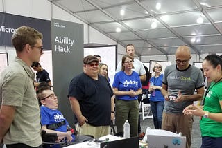 A crowd has formed around the Hackathon team as they demo their project for CEO Satya Nadella and CAO Jenny Lay-Flurrie.