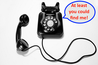 An old-fashioned, rotary dial phone rests on a grey background. Its speech bubble reads: “At least you could find me!”