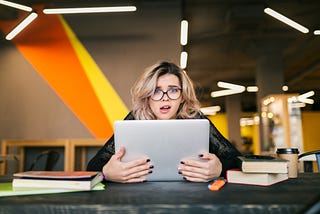 young, frazzled worker at a desk with her laptop