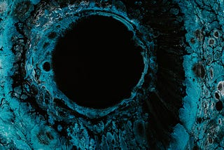 Image of a crater or hole, dark and colored blue.