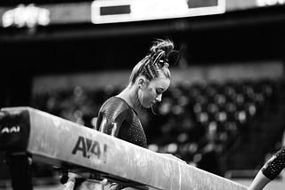 Female gymnast looking at a balance beam