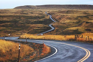 A road weaving through open land.