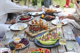 Group of people eating on a backyard. Photo by Lee Myungseong on Unsplash.