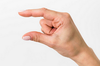 A photo of a person’s hand with their thumb and index finger held about one inch apart.