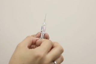 Hand holding vaccine syringe