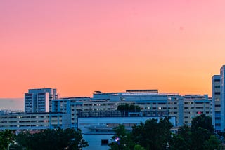 a dark blue skyline set against a bright orange sunset