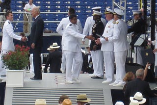 A man in unform receiving his degree on graduation