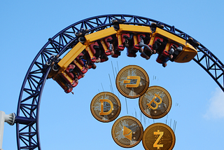 Coins with cryptocurrency logos fall from an upside down rollercoaster.